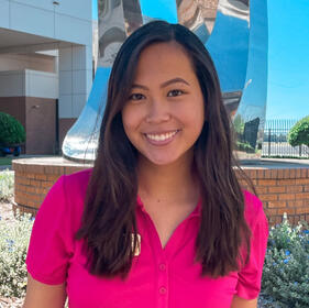 An image of Carly, wearing her pink Women's Ambassador polo.